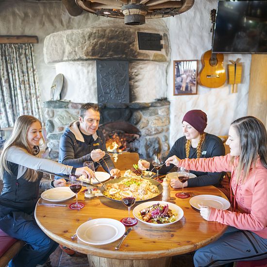 Freunde sitzen zusammen am Tisch und essen.