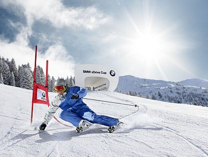 Skifahrer fährt mit blauem Skianzug eng an einem Riesentorlauftor vorbei, im Hintergrund ein Starthaus mit der Aufschrift BMW xDrive Cup