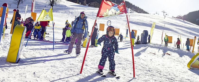Kind fährt durch Hinderniss bei einem Skirennen.