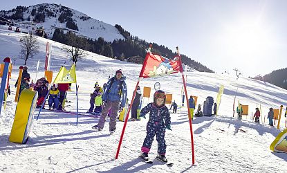 Kind fährt durch Hinderniss bei einem Skirennen.