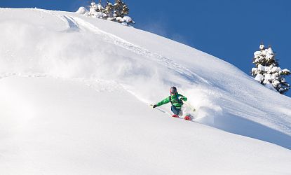 Skifahrer der im Tiefschnee fährt.
