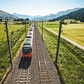 Zug fährt auf Schienen im Sommer.