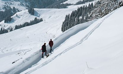 Zwei Winterwanderer die durch die SkiWelt Ellmau-Going wandern.
