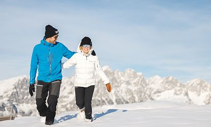 Zwei Winterwanderer die von der Brandstadl Bergstation zum Brandstadlkreuz in Scheffau wandern.