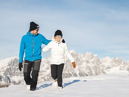 Zwei Winterwanderer die von der Brandstadl Bergstation zum Brandstadlkreuz in Scheffau wandern.