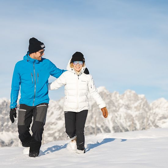 Zwei Winterwanderer die von der Brandstadl Bergstation zum Brandstadlkreuz in Scheffau wandern.